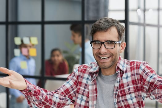 Happy young businessman spreading his hands apart to welcome