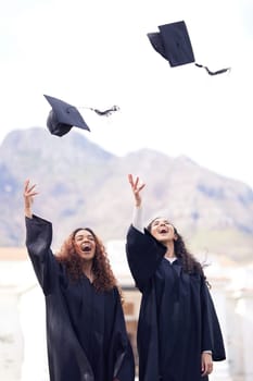 Graduation cap, excited friends and throw in air for celebration, study success and achievement on campus. University students, happy people or women celebrate for college, school and education.