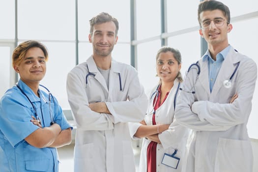 Successful team of medical doctors are looking at camera and smiling while standing
