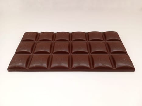 Dark chocolate bar texture isolated on white background from back view. Milk chocolate photo