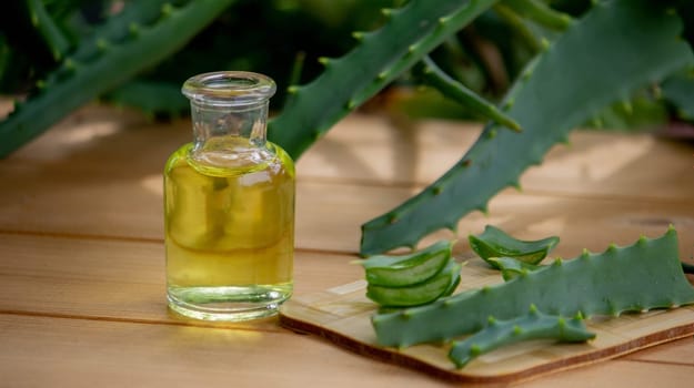 aloe vera essential oil on a wooden background, juice. Selective focus