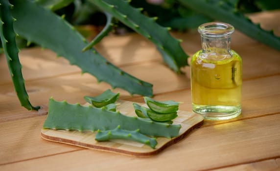 aloe vera essential oil on a wooden background, juice. Selective focus