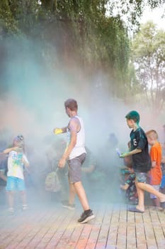 Lviv, Ukraine - July 18, 2021: Color Holi Festival, a crowd of people adults and small children throw colorful paint. Indian holiday