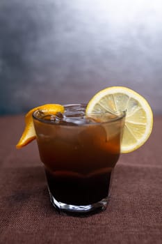 alcoholic drink with Cola and a slice of lemon in a glass.