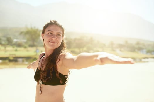 Yoga is my escape. a beautiful young woman practising yoga on the beach