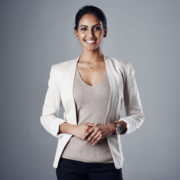 Self belief is key to having a successful career. Studio portrait of a young businesswoman posing against a gray background