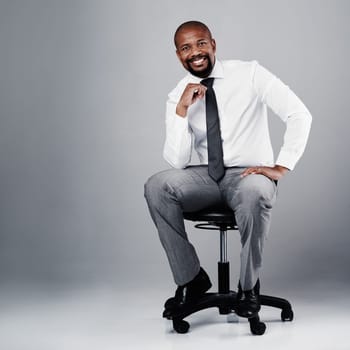 As a leader, youve got to be a forward-thinker. Studio portrait of a corporate businessman sitting on a chair against a grey background
