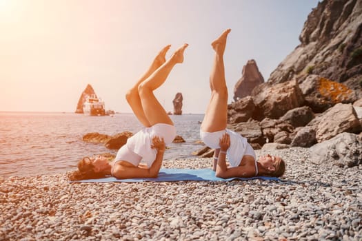 Woman sea yoga. Back view of free calm happy satisfied woman with long hair standing on top rock with yoga position against of sky by the sea. Healthy lifestyle outdoors in nature, fitness concept.