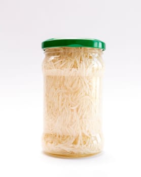 Isolated Celery Root Salad Preserve In Glass Jar With Screw Metal Cap On White Background. Shredded And Pickled Celery Crops, Tuber. Apium Graveolens, Culinary. Vertical Plane.