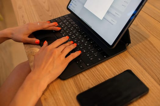 beautiful woman sitting in a cafe and working on a tablet. bali