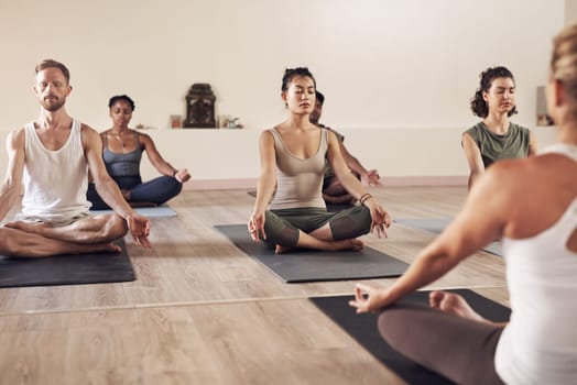 Yoga, meditation and class group in a wellness and health practice to relax with zen and peace. Female people, spiritual and holistic exercise with calm lotus pose with body balance on a gym mat.