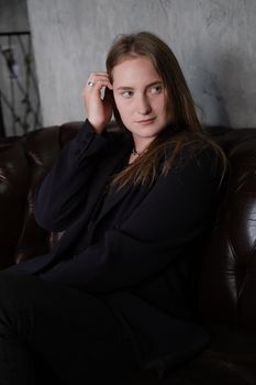 portrait of confident woman in black in dark room. pensive serious people. business woman. feminine. millennial people.