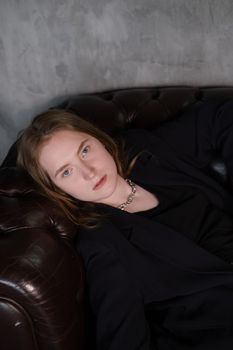 portrait of confident serious brunette woman in black clothes on dark background. femininity.