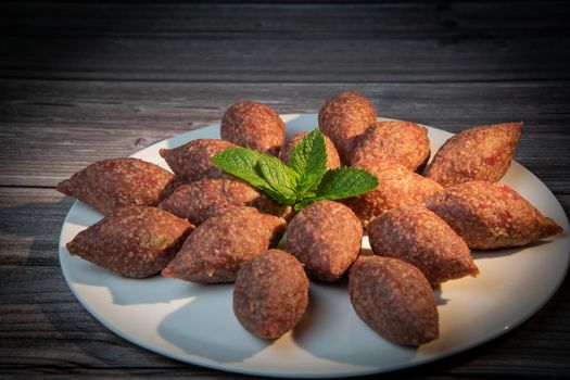 Traditional kebbe and pita bread on big round plate in lebanese restaurant. High quality photo