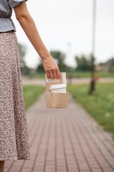 White paper cup with coffee in woman hand. Time for drink coffee in city. Coffee to go. Enjoy moment, take a break. Disposable paper cup closeup. Delicious hot beverage. Blank space for text, mockup