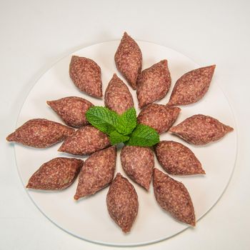 Traditional kebbe and pita bread on big round plate in lebanese restaurant. High quality photo