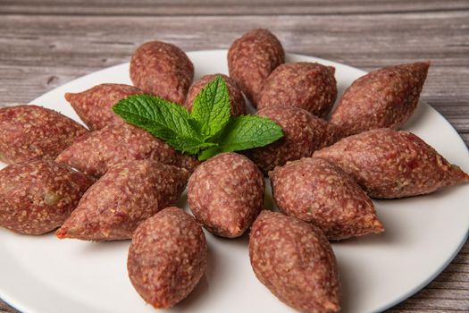 Traditional kebbe and pita bread on big round plate in lebanese restaurant. High quality photo
