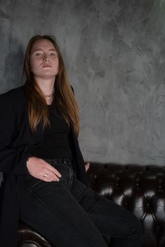 portrait of confident woman in black in dark room. pensive serious people. business woman. feminine. millennial people.