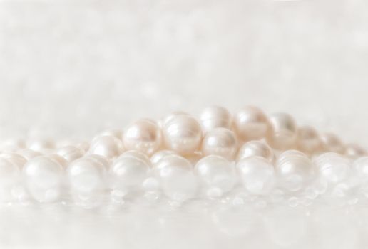 Nature white string of pearls on a sparkling background in soft focus, with highlights