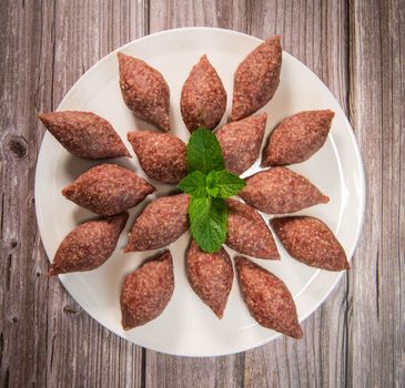 Traditional kebbe and pita bread on big round plate in lebanese restaurant. High quality photo