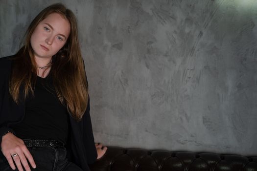 portrait of confident woman in black in dark room. pensive serious people. business woman. feminine. millennial people.