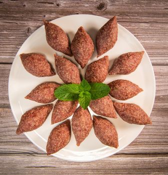 Traditional kebbe and pita bread on big round plate in lebanese restaurant. High quality photo