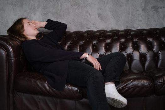 portrait of confident woman in black in dark room. pensive serious people. business woman. feminine. millennial people.