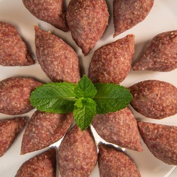 Traditional kebbe and pita bread on big round plate in lebanese restaurant. High quality photo