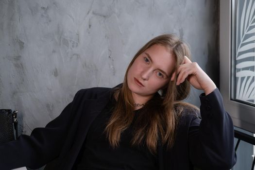 portrait of confident serious brunette woman in black clothes on dark background. femininity.