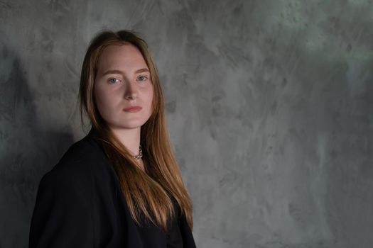 portrait of confident woman in black in dark room. pensive serious people. business woman. feminine. millennial people.