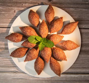 Traditional kebbe and pita bread on big round plate in lebanese restaurant. High quality photo