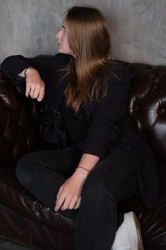 portrait of confident woman in black in dark room. pensive serious people. business woman. feminine. millennial people.