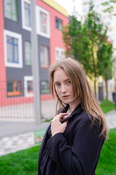 pretty brunette woman on background of bright modern buildings. feminine. millennial people. lady on walk.