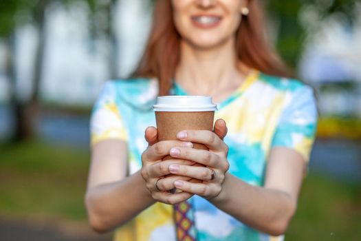 White paper cup with coffee in woman hand. Time for drink coffee in city. Coffee to go. Enjoy moment, take a break. Disposable paper cup closeup. Delicious hot beverage. Blank space for text, mockup