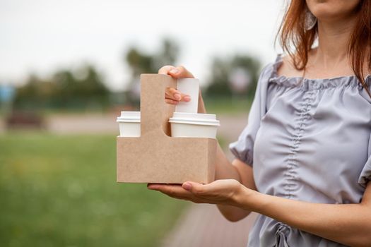 Two white paper cup with coffee in woman hand. Time for drink coffee in city. Coffee to go. Enjoy moment, take a break. Disposable paper cup closeup. Delicious hot beverage. Blank space for text,