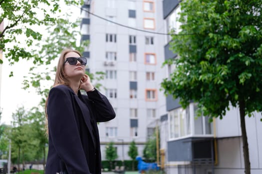 pretty brunette woman on background of bright modern buildings. feminine. millennial people. lady on walk.