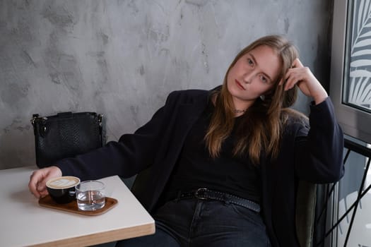 charming confident brunette woman in a cafe with coffee. coffee break. business woman.