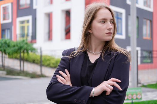 pretty brunette woman on background of bright modern buildings. feminine. millennial people. lady on walk.