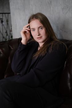 portrait of confident serious brunette woman in black clothes on dark background. femininity.