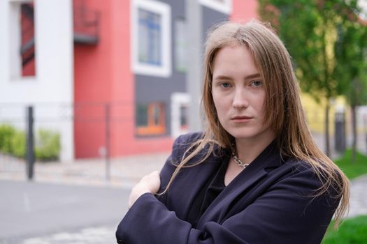 pretty brunette woman on background of bright modern buildings. feminine. millennial people. lady on walk.