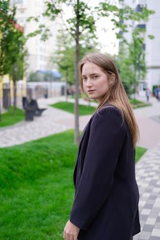 pretty brunette woman on background of bright modern buildings. feminine. millennial people. lady on walk.