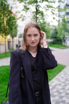 pretty brunette woman on background of bright modern buildings. feminine. millennial people. lady on walk.