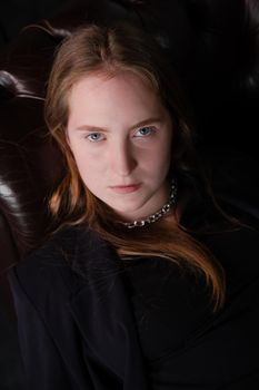 portrait of confident serious brunette woman in black clothes on dark background. femininity.