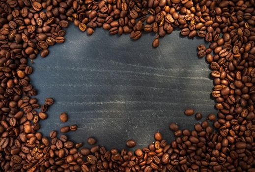 Coffee beans over slate. Top view. Free space for text
