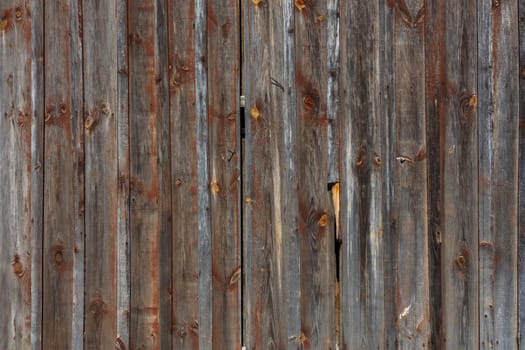 artistic texture of an old wooden planks fence in black and brown tones - close-up rustic background