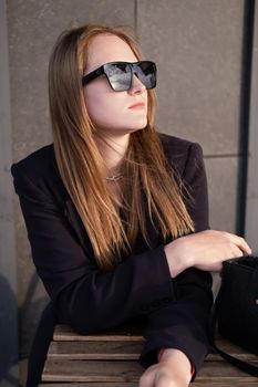 pretty brunette woman sitting by wooden table outside. feminine. millennial people. lady on coffee break.