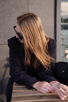 pretty brunette woman sitting by wooden table outside. feminine. millennial people. lady on coffee break.