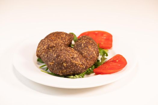 Traditional kebbe and pita bread on big round plate in lebanese restaurant. High quality photo