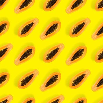 Fresh ripe papaya seamless pattern on yellow background. Tropical abstract background. Top view. Creative design, minimal flat lay concept. Trend tropical fruit food background pattern