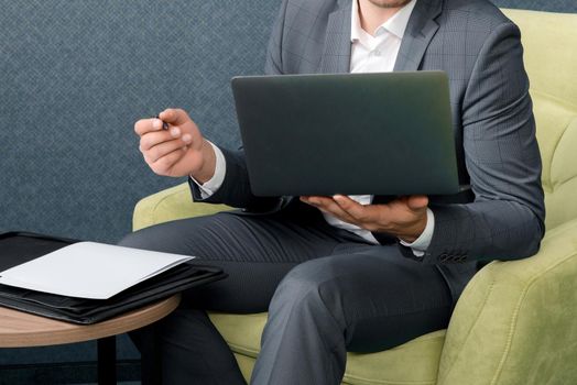 Young businessman working on laptop, sitting in hotel